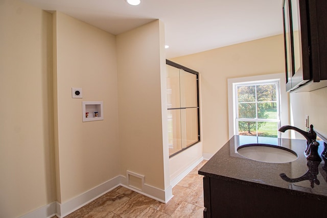 bathroom with vanity and enclosed tub / shower combo