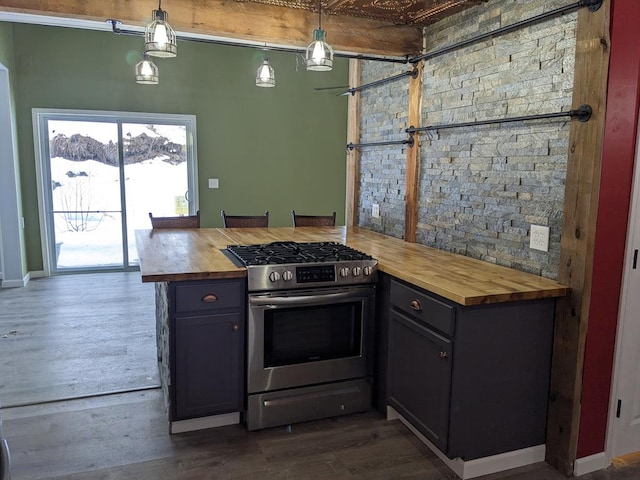 kitchen with pendant lighting, dark hardwood / wood-style floors, gas stove, and butcher block counters