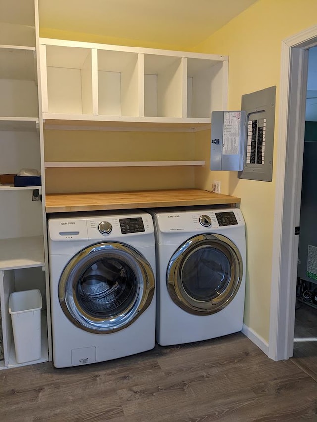 clothes washing area with dark hardwood / wood-style floors, electric panel, and washer and dryer