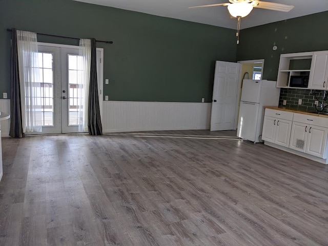 kitchen with white cabinets, white refrigerator, ceiling fan, light hardwood / wood-style floors, and french doors