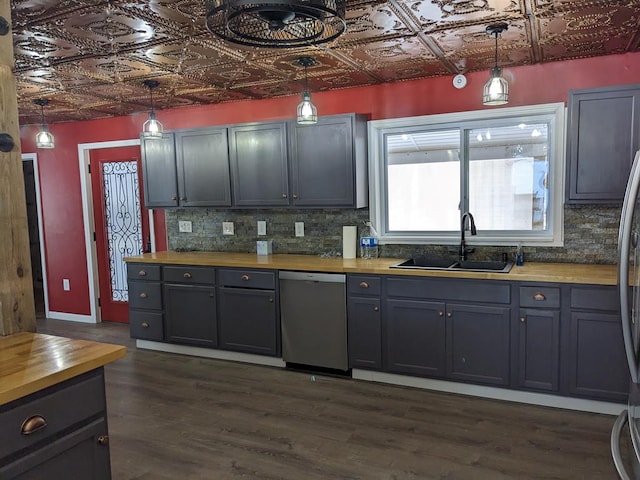 kitchen with butcher block counters, sink, decorative light fixtures, and dishwasher