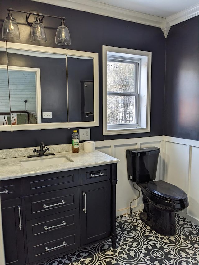 bathroom featuring tile patterned flooring, ornamental molding, vanity, and toilet