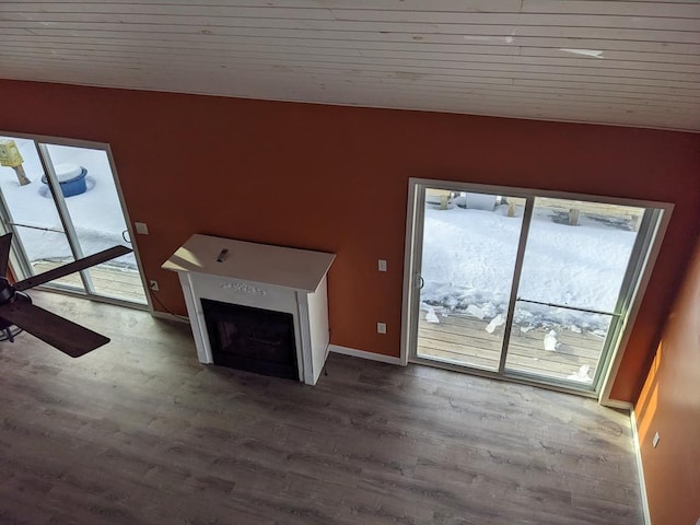 unfurnished living room featuring hardwood / wood-style flooring, a healthy amount of sunlight, and wooden ceiling