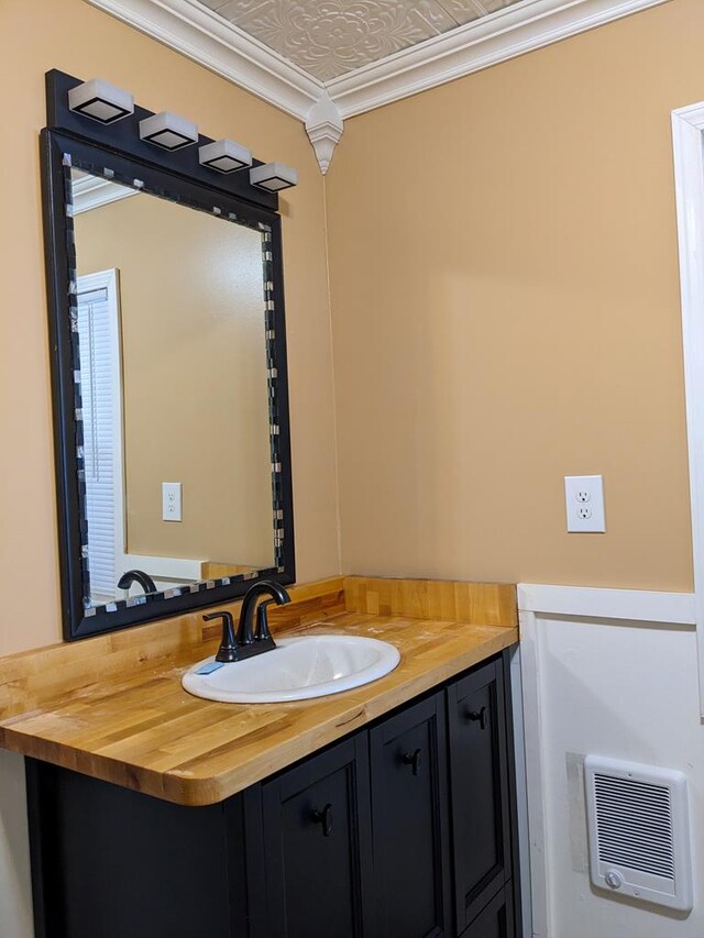 bathroom with ornamental molding and vanity