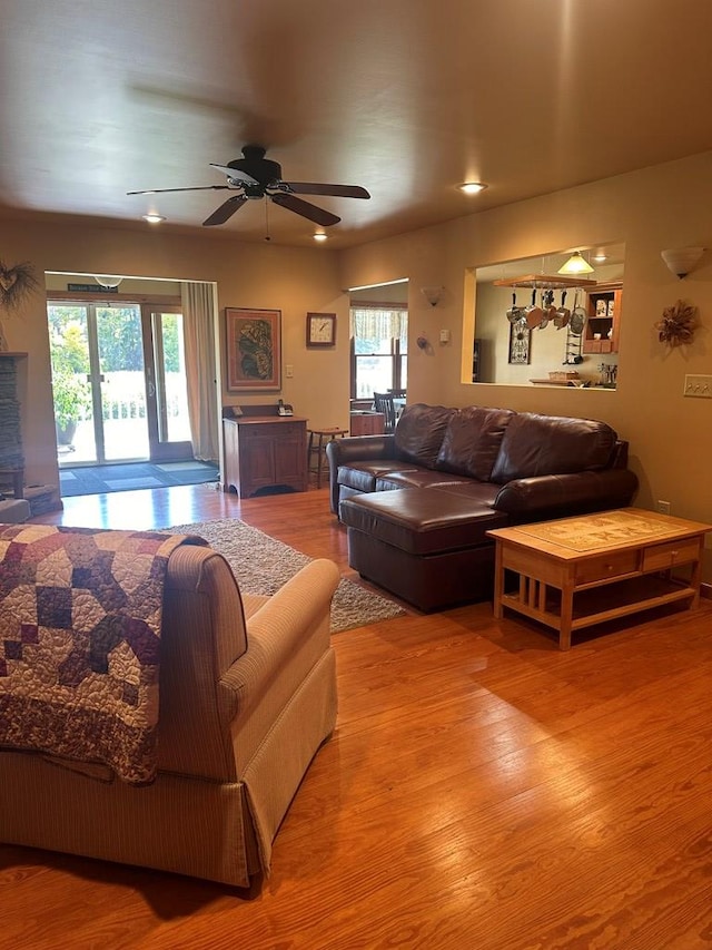 living room with hardwood / wood-style floors, ceiling fan, and a healthy amount of sunlight