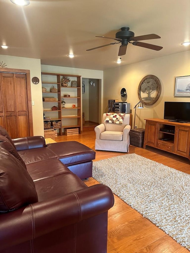 living room featuring light hardwood / wood-style flooring and ceiling fan