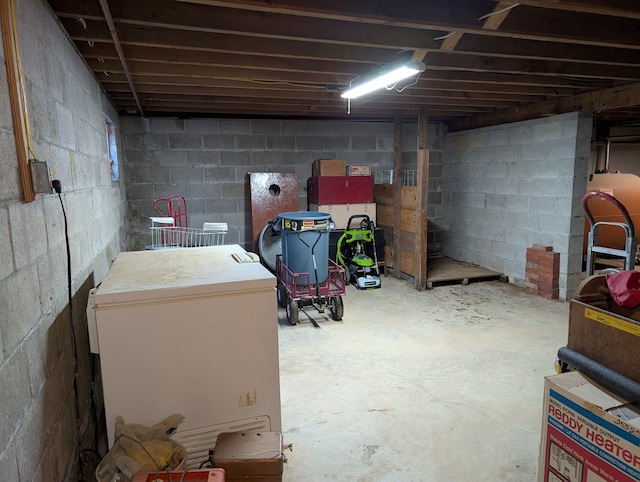 unfinished basement featuring fridge