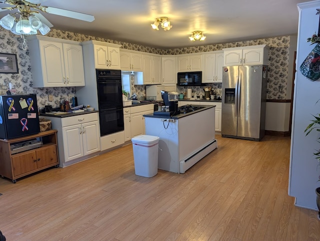 kitchen with black appliances, dark countertops, white cabinetry, and wallpapered walls