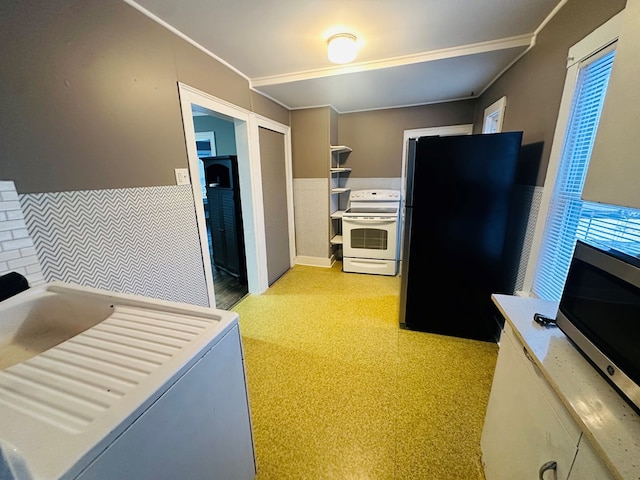 kitchen with ornamental molding, washer / dryer, and stainless steel appliances