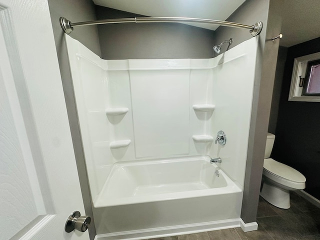 bathroom with toilet and bathing tub / shower combination