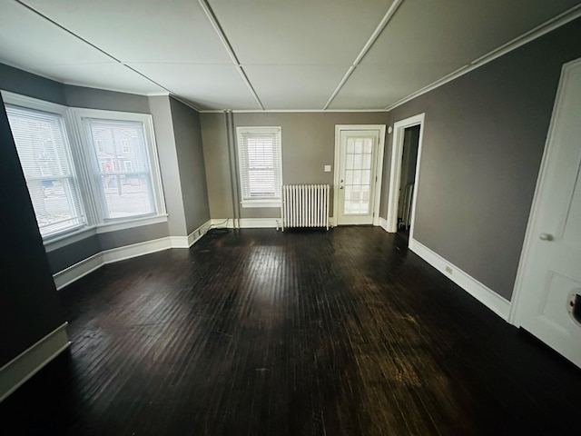 spare room featuring dark hardwood / wood-style floors and radiator