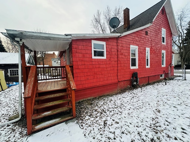 snow covered property with a wooden deck