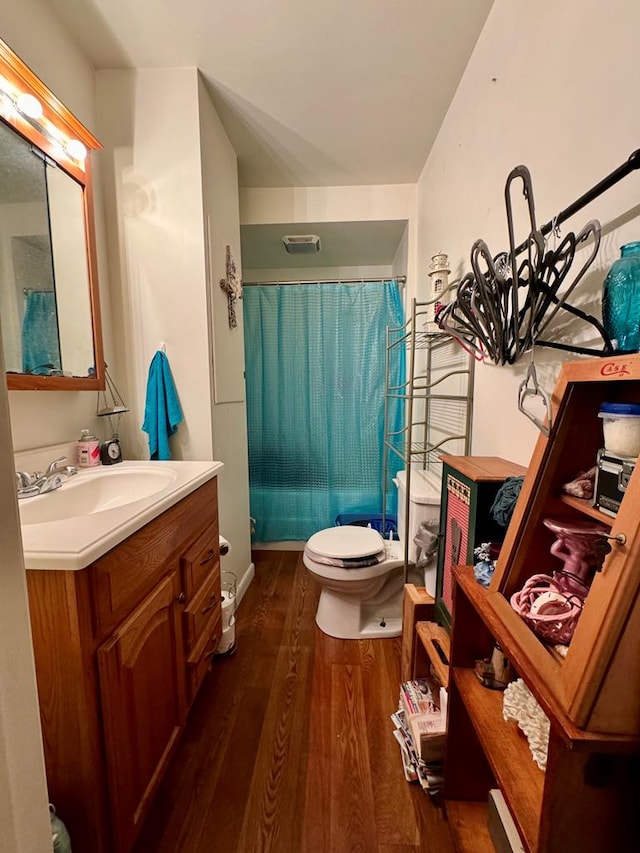 bathroom featuring walk in shower, toilet, vanity, and hardwood / wood-style flooring