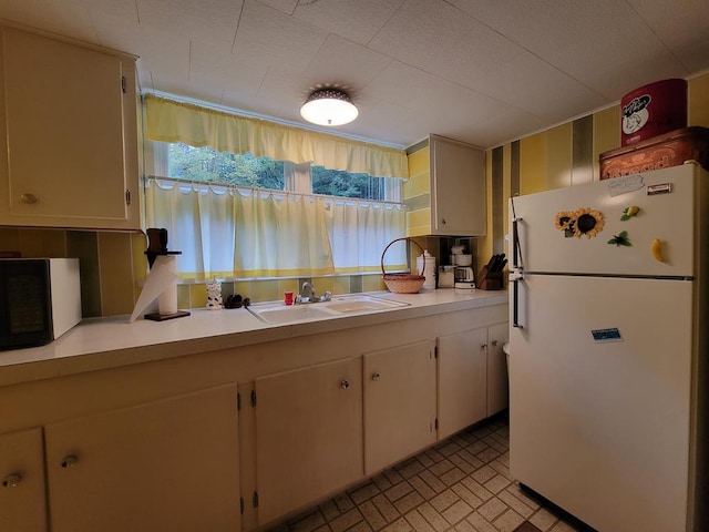 kitchen featuring sink, white cabinets, and white refrigerator