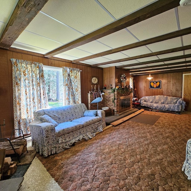 living room featuring carpet flooring, wooden walls, and beamed ceiling