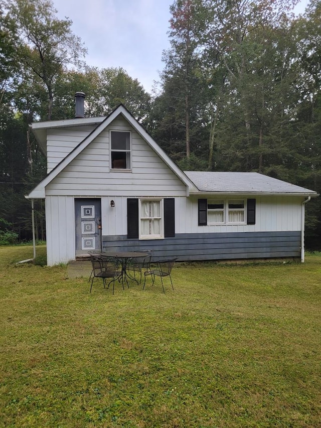 back of property featuring a yard