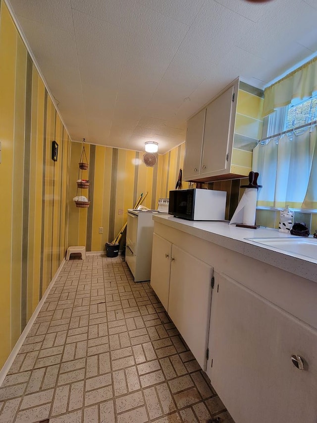 kitchen with washer / clothes dryer and white cabinetry