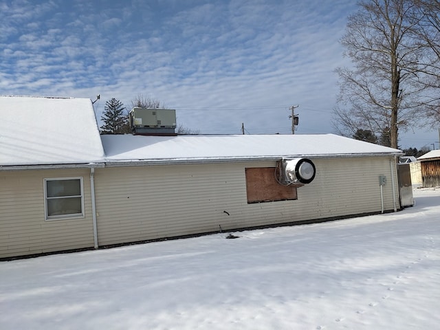 snow covered property featuring central air condition unit