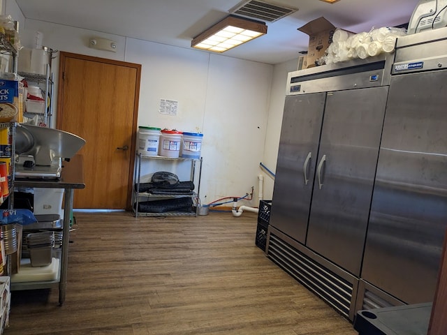 kitchen with dark hardwood / wood-style flooring and stainless steel refrigerator