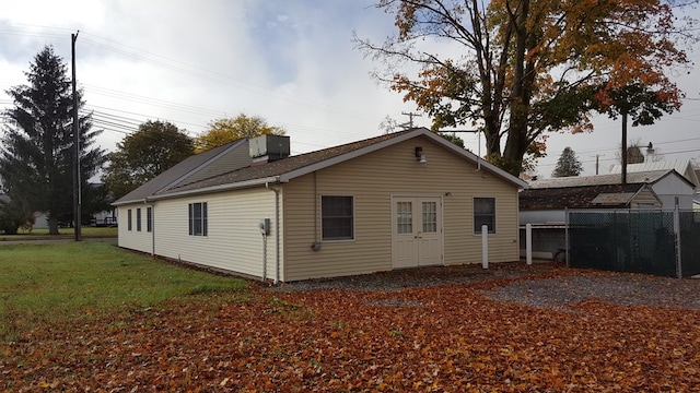 rear view of property featuring a yard and central AC unit