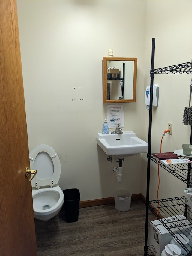 bathroom featuring hardwood / wood-style flooring, toilet, and sink