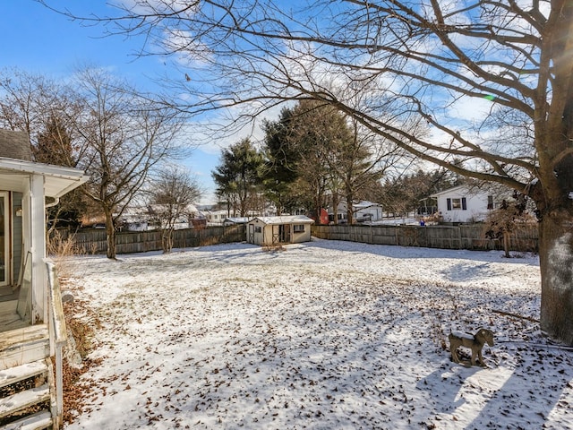 yard covered in snow with a storage shed