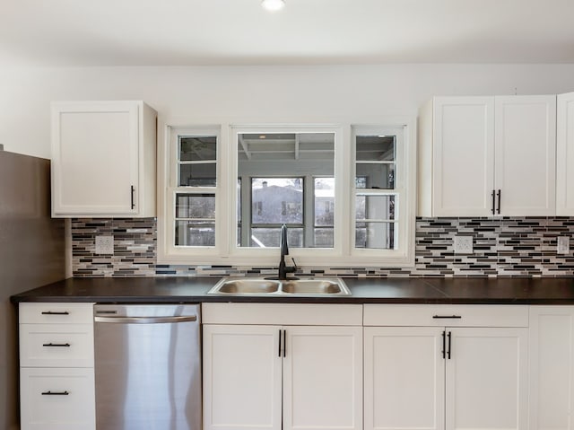 kitchen with decorative backsplash, sink, white cabinets, and stainless steel dishwasher