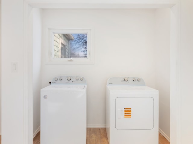 laundry area with washer and dryer and light hardwood / wood-style floors