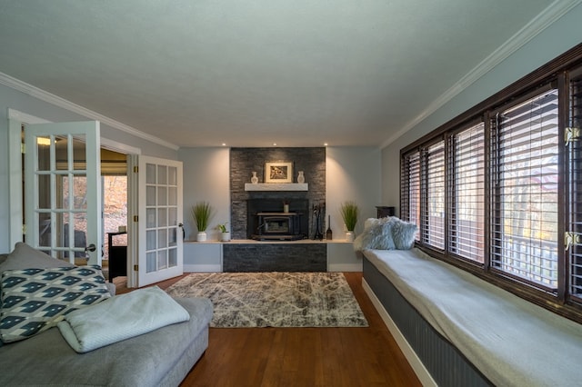 living room with ornamental molding, hardwood / wood-style flooring, a wood stove, and a healthy amount of sunlight