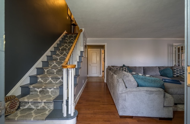 living room featuring crown molding, wood-type flooring, and a textured ceiling