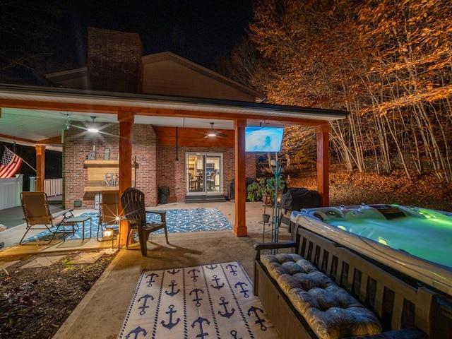 view of patio / terrace featuring a fireplace, a hot tub, and ceiling fan