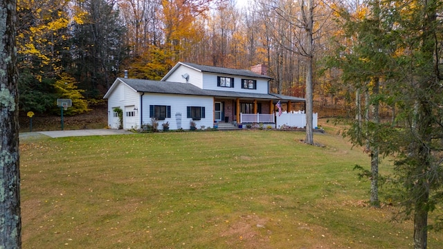 view of front of house featuring a garage, covered porch, and a front yard