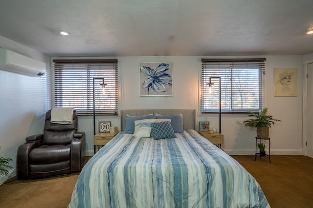 bedroom with a wall mounted air conditioner, a textured ceiling, and carpet