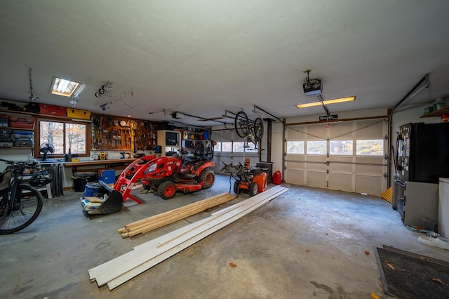 garage with a workshop area, black fridge, and a garage door opener