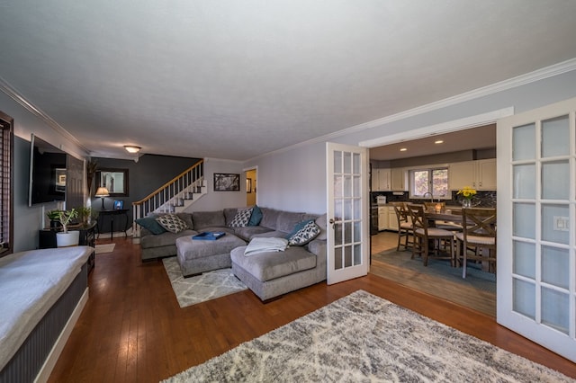 living room featuring hardwood / wood-style flooring, crown molding, and french doors