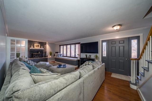 living room featuring a fireplace, dark hardwood / wood-style flooring, and crown molding