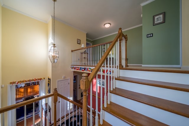 stairway with ornamental molding and a chandelier