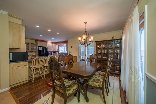 dining area with crown molding, wood-type flooring, and a chandelier