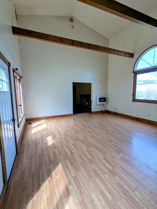unfurnished living room featuring high vaulted ceiling, light wood-style flooring, heating unit, and beam ceiling