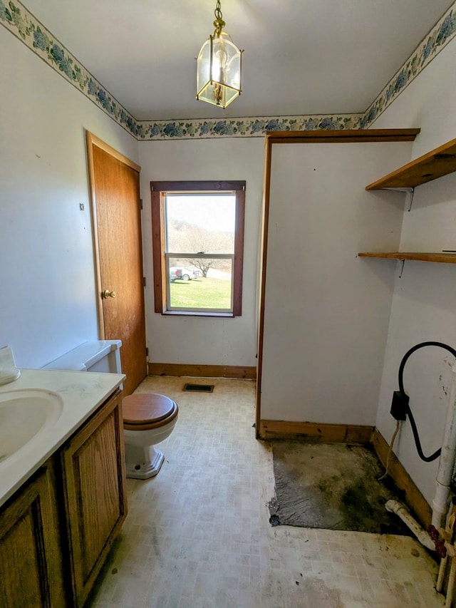 bathroom featuring visible vents, toilet, vanity, and baseboards