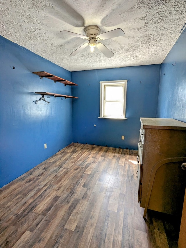 unfurnished bedroom with ceiling fan, wood finished floors, and a textured ceiling