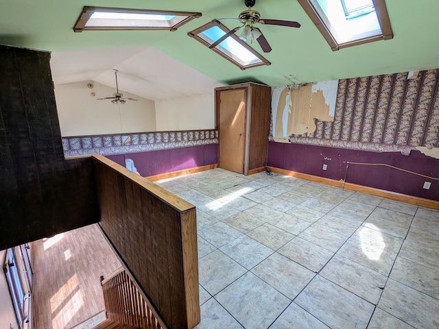 interior space with vaulted ceiling with skylight and ceiling fan