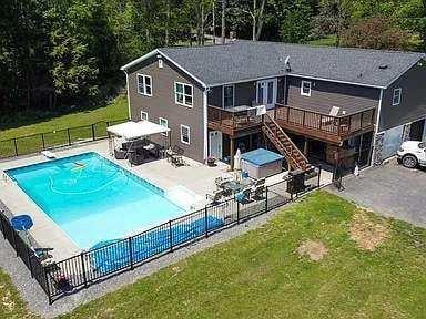 view of pool with a lawn, a wooden deck, and a patio