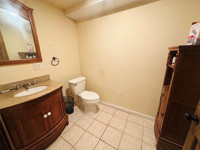 bathroom featuring toilet, baseboards, vanity, and tile patterned floors