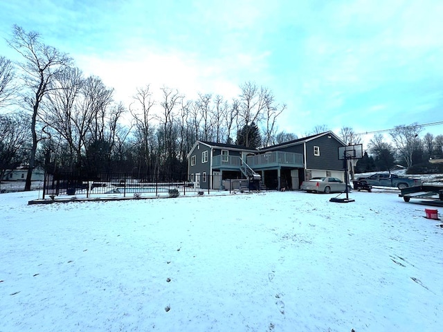 exterior space featuring a garage, fence, stairway, and a wooden deck