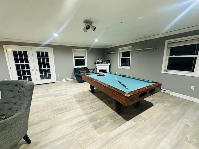 recreation room with a baseboard radiator, light hardwood / wood-style flooring, ornamental molding, and french doors