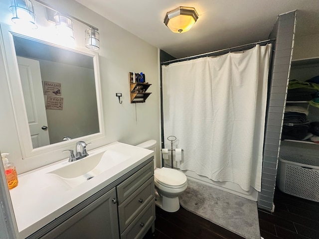 bathroom with toilet, shower / bath combination with curtain, wood finished floors, and vanity