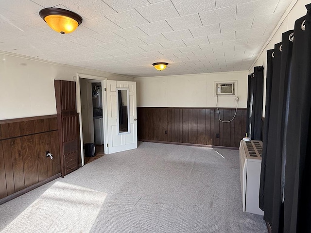 carpeted spare room with wooden walls, a wainscoted wall, and a wall mounted air conditioner
