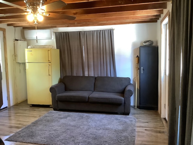 living room featuring ceiling fan, beam ceiling, and light wood-type flooring