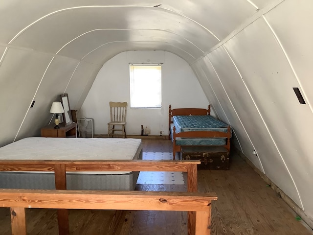 bedroom with dark hardwood / wood-style flooring and vaulted ceiling